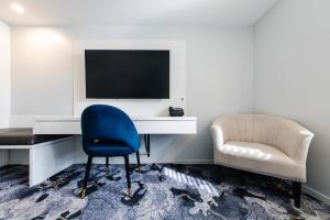 a room with a desk and a chair and a television at Hotel Kingsley in Brisbane +54 photos