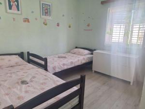 a bedroom with two beds and a window at Apartman Juran in Murter