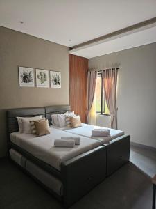 a large bed in a room with a window at Annapurna Resort Puncak in Tagalbato +35 photos