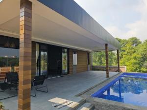 a home with a swimming pool and a house at Annapurna Resort Puncak in Tagalbato