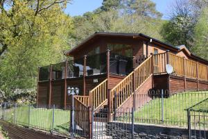 a log cabin with a porch and a fence at High View Lodge in Windermere