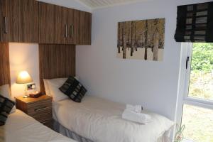a bedroom with two beds and a window at High View Lodge in Windermere
