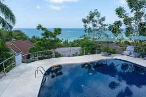 a swimming pool with a view of the ocean at v14 Serenity Bay Panoramic Sea View in Haad Yao