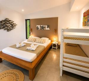 a bedroom with a bed and a bunk bed at Lilie Location Sapotis in Saint-Joseph