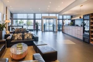 a living room with couches and a glass table at Hotel Wolfsburg Centrum, Affiliated by Meliá in Wolfsburg