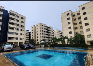 a large swimming pool in a parking lot with buildings at Garden aconchegante in Manaus