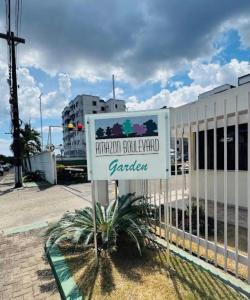 a sign in front of a white fence at Garden aconchegante in Manaus