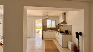 a kitchen with white cabinets and a view of a patio at Lióspito & Kochýli Constellation in Néa Koróni
