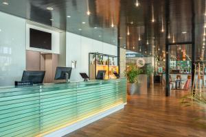 a lobby with a bar with a tv on the wall at INNSiDE by Meliá Düsseldorf Seestern in Düsseldorf