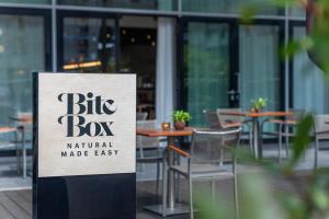 a sign in front of a restaurant with tables and chairs at INNSiDE by Meliá Düsseldorf Seestern in Düsseldorf