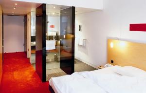 a hotel room with a bed and a mirror at INNSiDE by Meliá Düsseldorf Seestern in Düsseldorf