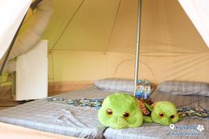 two green octopus sitting on a bed in a tent at ชบาเฮาส์โฮมสเตย์ 