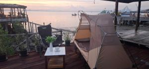 a tent sitting on a deck next to the water at ชบาเฮาส์โฮมสเตย์ 