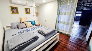 a bed with pillows on it in a room at ชบาเฮาส์โฮมสเตย์ 