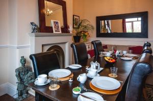 a dining room with a table and chairs and a mirror at Arlana Guest House in Cleethorpes