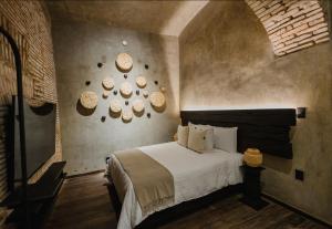 a bedroom with a bed and some plates on the wall at Casa Levonka in Oaxaca City