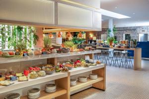 a restaurant with a buffet of food on display at INNSiDE by Meliá Berlin Mitte in Berlin
