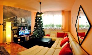 ein Wohnzimmer mit einem Weihnachtsbaum und einer Couch in der Unterkunft 7 Star Wishes in Liptovský Hrádok