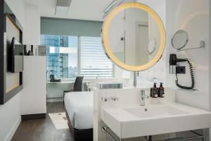 a bathroom with a sink and a mirror at INNSiDE by Meliá Düsseldorf Hafen in Düsseldorf