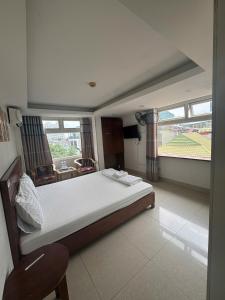 a bedroom with a bed and a chair and windows at Hanoi Gold Hotel Near Bach Mai in Hanoi