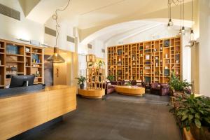 a library with bookshelves and couches in a building at INNSiDE by Meliá Prague Old Town in Prague