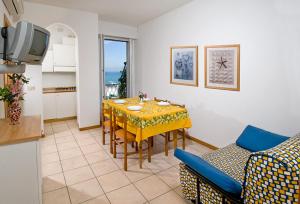 eine Küche und ein Esszimmer mit einem Tisch und Stühlen in der Unterkunft Residence Bellevue in Gabicce Mare