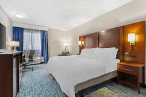 a hotel room with a large bed and a television at Garner Hotel Warren Northwest by IHG in Warren +40 photos
