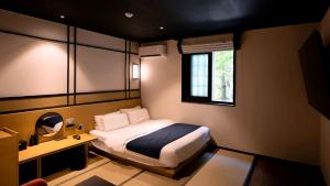 a bedroom with a bed and a desk and a window at Mitasuya Ryokan Hotel Daejeon Yuseong in Daejeon +113 photos