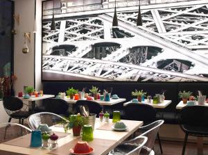a restaurant with tables and chairs and a picture of the eiffel tower at Hotel Paris Opéra, Affiliated by Meliá in Paris