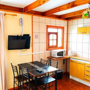 a kitchen with a table and chairs and a television at Apart Hotel Caldera - Room in Caldera