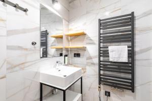 a white bathroom with a sink and a mirror at Willa Folc in Kościelisko