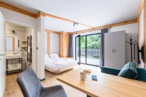 a room with a bed and a desk and chairs at Willa Folc in Kościelisko