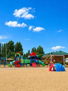 a park with a playground with slides and play equipment at Diona Raduga West in Koshkolʼ