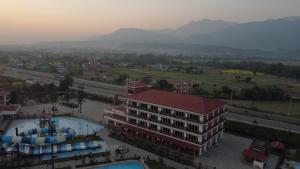 a building with a pool in front of a city at ila Comfort Harkapur in Maruwā Ghāt