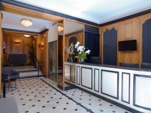 a hotel lobby with a reception desk and flowers at Meliá Paris Champs Elysées in Paris