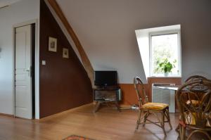 a living room with a table with a television and a window at Le gite d'Or in Vouvray