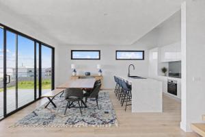 a kitchen and dining room with a table and chairs at The Bay View San Remo by Ready Set Stay- BYO LINEN & TOWELS in San Remo