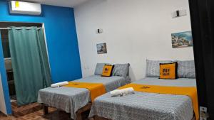 a room with two twin beds with orange pillows at Mi Hotel Club in Lázaro Cárdenas