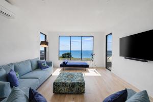 a living room with a couch and a flat screen tv at The Bay View San Remo by Ready Set Stay- BYO LINEN & TOWELS in San Remo