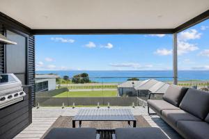 a living room with a couch and a view of the ocean at The Bay View San Remo by Ready Set Stay- BYO LINEN & TOWELS in San Remo