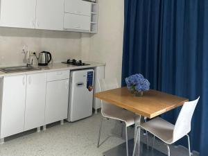 a small kitchen with a table and a blue curtain at SOPHIA Hotel Ureki in Ureki