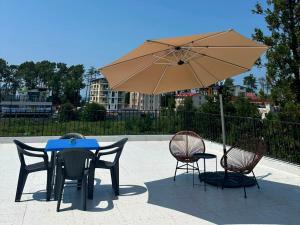 a table and chairs with a blue table and an umbrella at SOPHIA Hotel Ureki in Ureki
