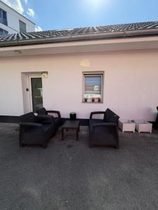 a patio with couches and a window on a building at Grenz-Apartment an der Aach in Rielasingen-Worblingen
