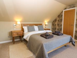 a bedroom with a large bed with towels on it at Whitehouse Woodwrae in Forfar +54 photos