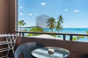 a table and chairs on a balcony with a view of the ocean at Rockstar Beach Apartments in Bangrak Beach