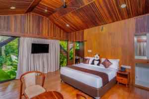 a bedroom with a bed and a tv in it at Wood Panda Luxury Resort Wayanad in Meppādi +180 photos