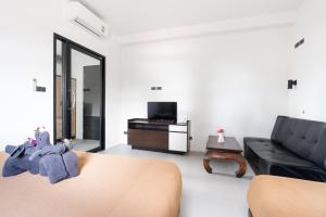 a living room with a couch and a tv at Rockstar Beach Apartments in Bangrak Beach