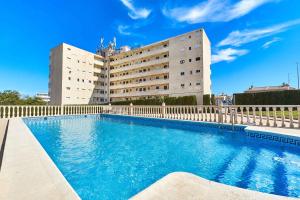 a building with a swimming pool in front of a building at Espanhouse Vera Torreblanca in Torrevieja