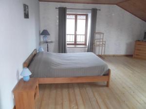 a bedroom with a large bed with a wooden floor at Gite le Sauceley Maison de vacances pour 6 à 10 personnes in Girmont-Val-dʼAjol