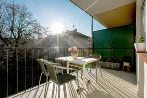 uma mesa e cadeiras numa varanda com sol em Apartment Cvetje em Zagreb